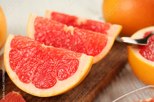 Sliced grapefruits with mint on wooden background, close up