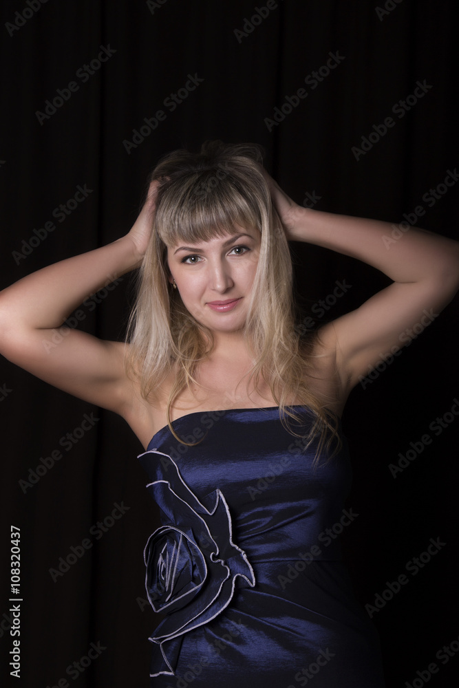 beautiful blonde girl in a blue dress on a dark background beautiful blonde girl in a blue dress on a dark background