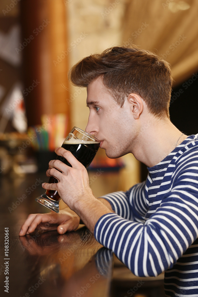 Young man drinking beer in a bar Young man drinking beer in a bar