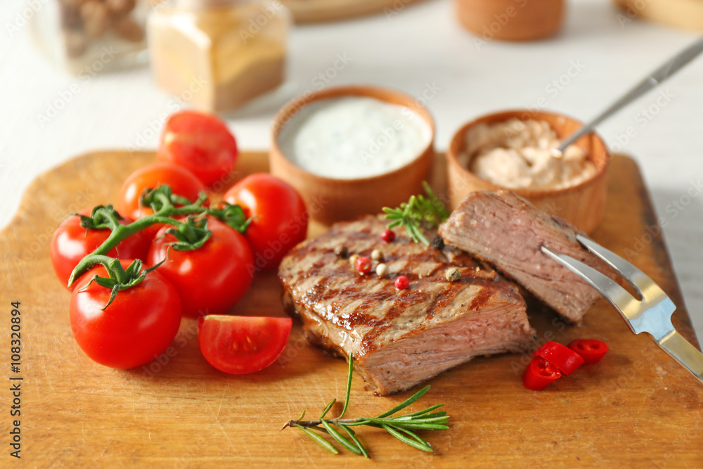Delicious grilled steak on cutting board, closeup Delicious grilled steak on cutting board, closeup