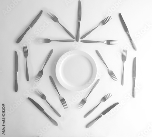 Plate, silver forks and knives, top view