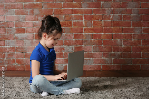 Little girl using laptop on...