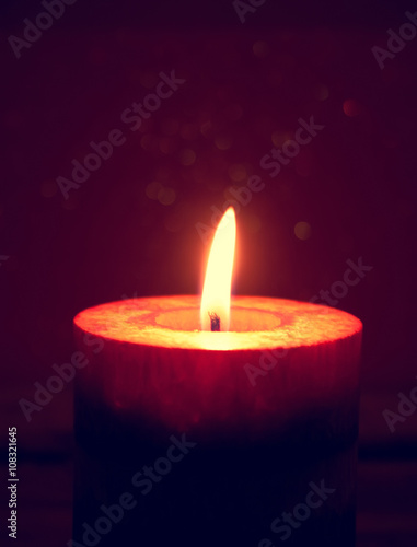 Red burning candles on rustic wooden table. 