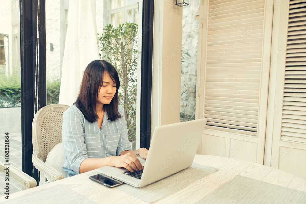 Happy casual beautiful woman watching videos or enjoying entertainment content in a laptop sitting in a coffee shop terrace outdoors in a sunny day Happy casual beautiful woman watching videos or enjoying entertainment content in a laptop sitting in a coffee shop terrace outdoors in a sunny day
