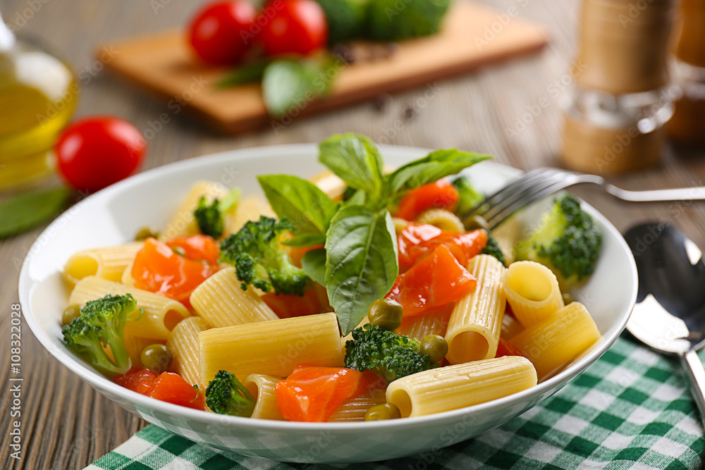 Plate of pasta with salmon and broccoli on table closeup Plate of pasta with salmon and broccoli on table closeup