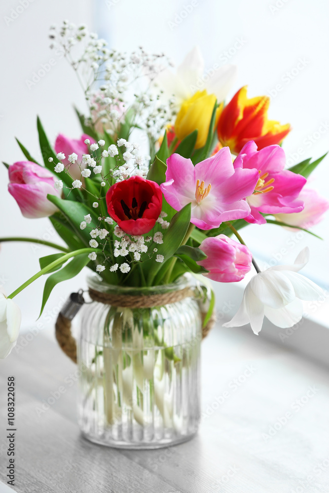 Bouquet of beautiful colorful tulips in glass vase on windowsill, indoors Bouquet of beautiful colorful tulips in glass vase on windowsill, indoors