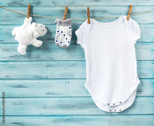 Baby boy clothes and white bear toy on a clothesline photo