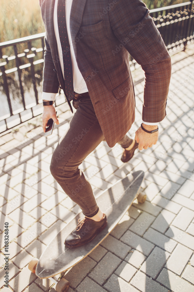 handsome young man with beard and sunglasses smart look office style boarding in the street and park handsome young man with beard and sunglasses smart look office style boarding in the street and park