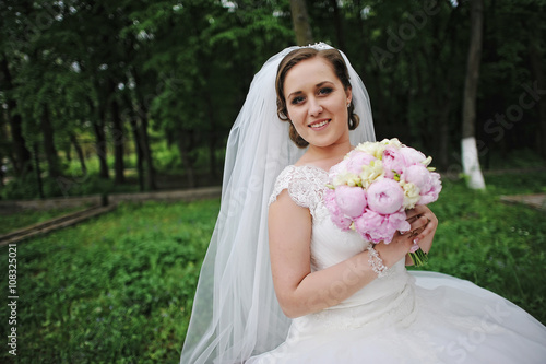 Close up portrait of beautiful bride with peonies wedding bouque