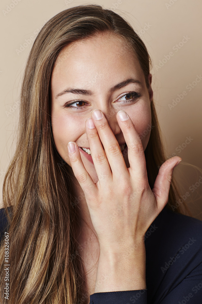 Beautiful woman covering smile in studio Beautiful woman covering smile in studio
