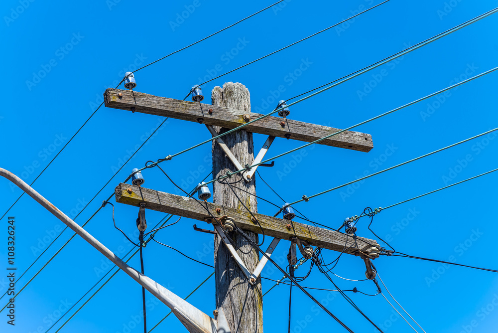 Old simple rural wood electrical pole on blue sky Old simple rural wood electrical pole on blue sky
