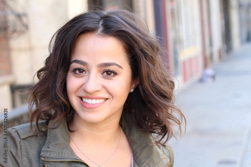 Portrait of naturally beautiful woman in her mid twenties with brown hair and brown eyes, shot outside in natural sunlight