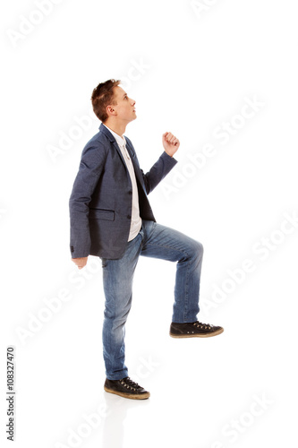 Side view of a businessman climbs the stairs