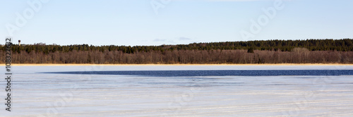 Wallpaper Mural Frozen lake and cloudy sky. The lake is covered with ice in the woods.  Torontodigital.ca