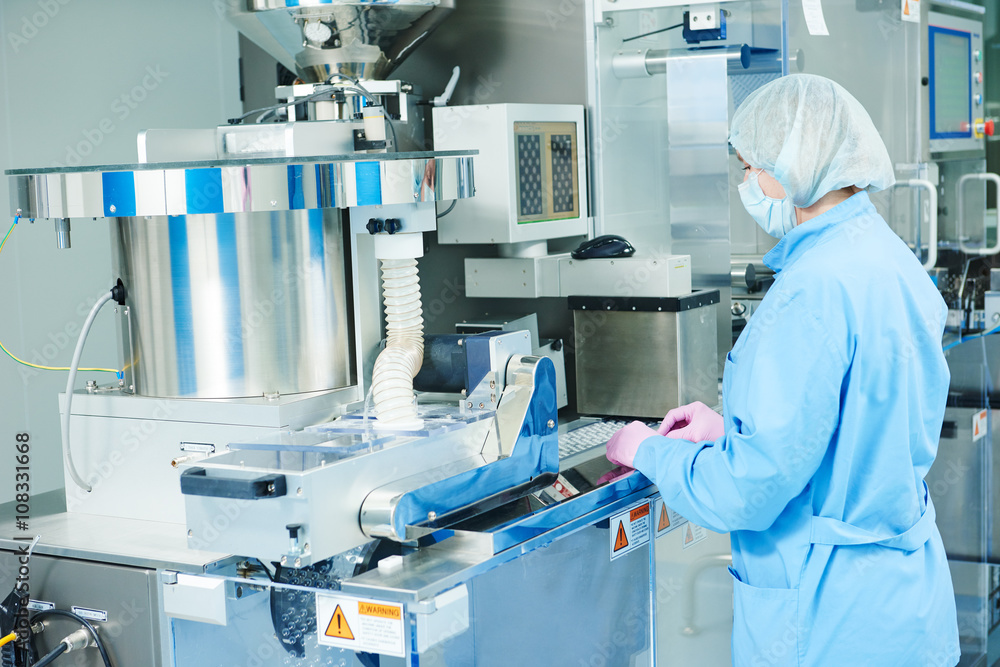 Pharmaceutics. Pharmaceutical worker operates blister packaging machine  - obrazy, fototapety, plakaty 