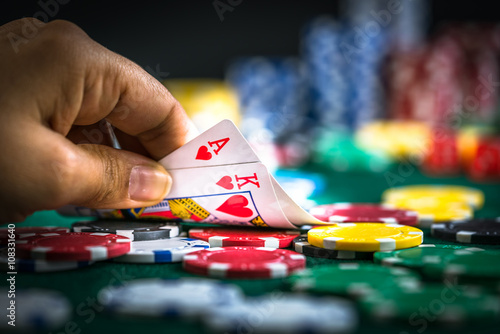 Schilderij op canvas Gambling Hand Holding Best Game Card Series and Money Chips