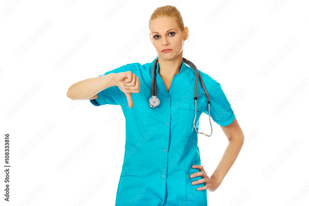 Young unhappy female doctor or nurse showing thumb down Young unhappy female doctor or nurse showing thumb down
