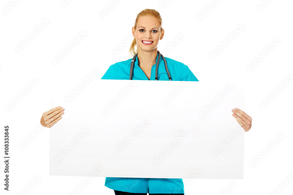Smiling female doctor or nurse holding empty banner Smiling female doctor or nurse holding empty banner