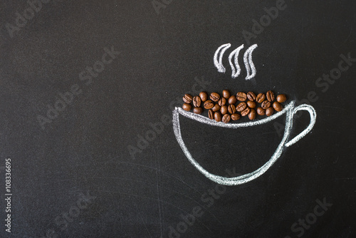 cup drawn with chalk on black board and real coffee beans