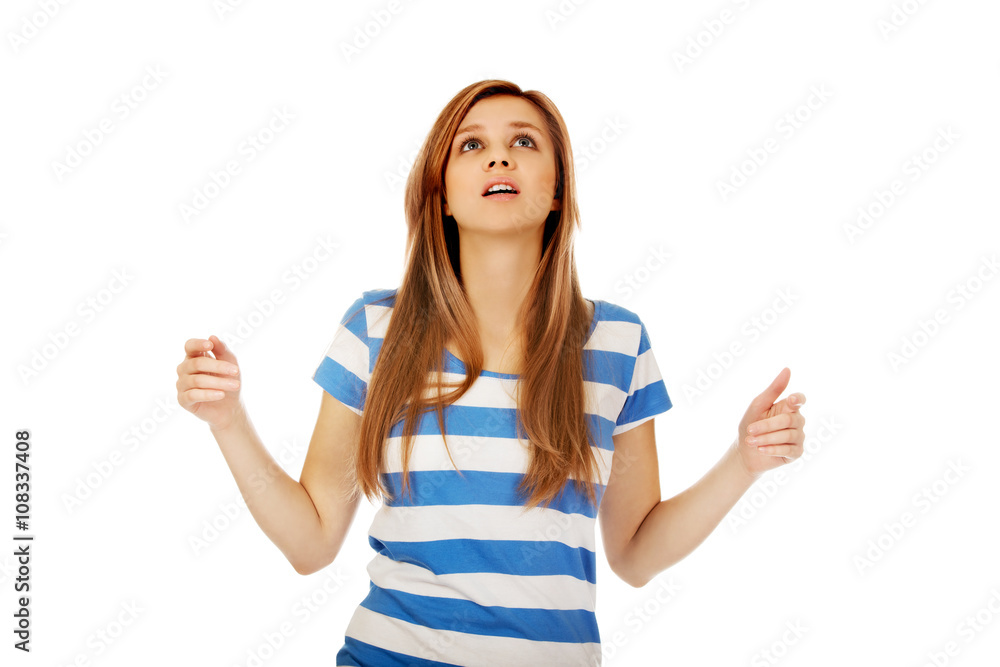 Teenage woman with outstretched arms looking up Teenage woman with outstretched arms looking up
