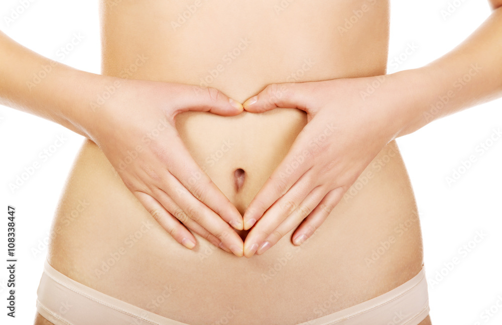 Woman is having heart shape made from hands on her belly Woman is having heart shape made from hands on her belly