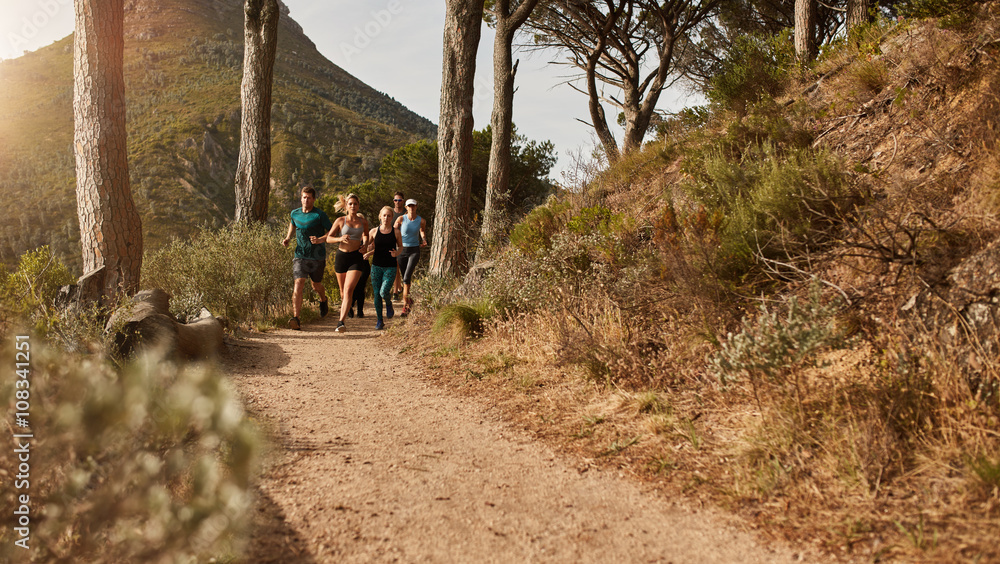 Athletes running together through trails on the hillside Athletes running together through trails on the hillside