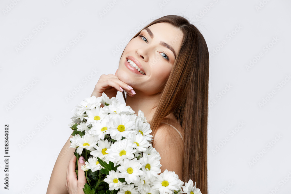 Beautiful Woman with Clean Fresh Skin holding flowers