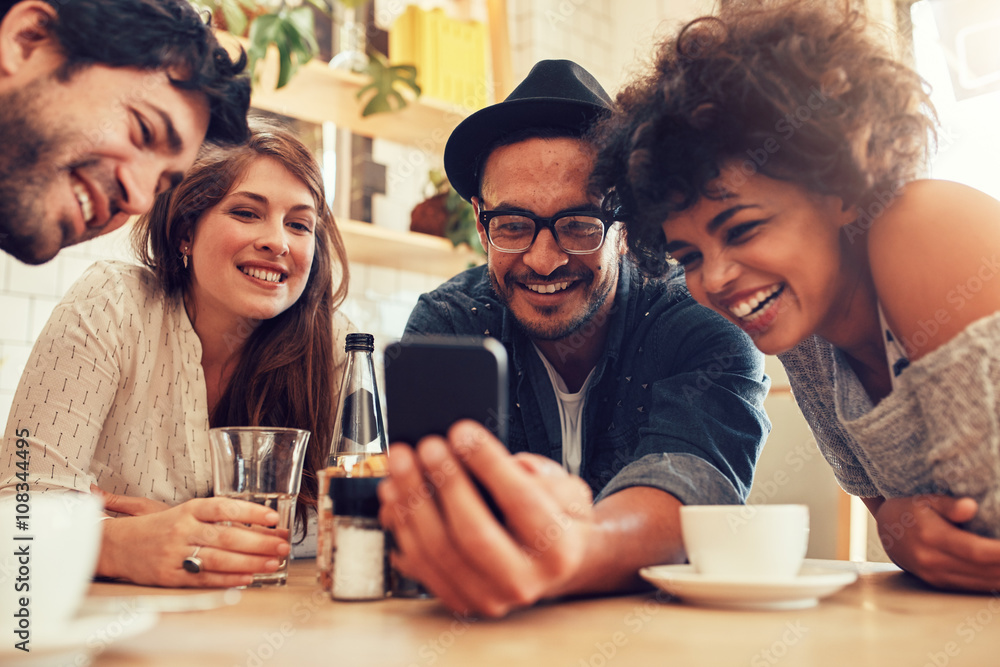 Friends watching photos on mobile phone Friends watching photos on mobile phone