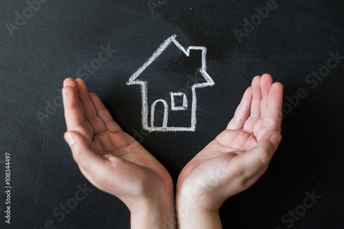 hands protects a house