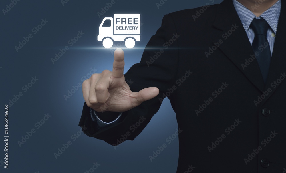 Businessman pressing free delivery truck icon on blue background Businessman pressing free delivery truck icon on blue background