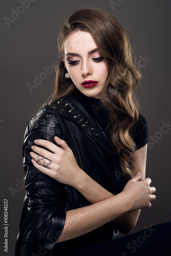 Fototapeta Glamorous young beautiful rock style girl in black leather jacket with accessori