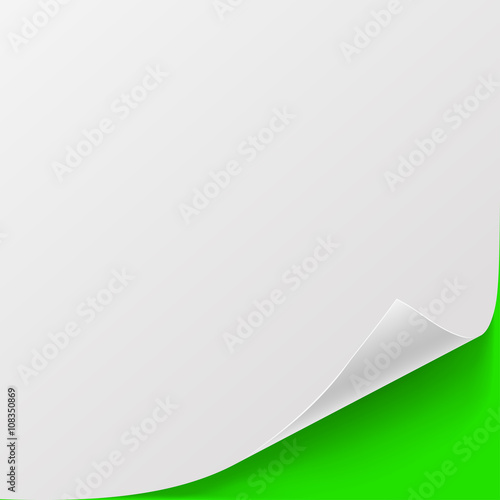 White sheet of paper with curved corner and with shadow on green