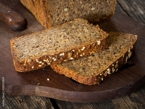 Tableau sur toile Sourdough rye bread with seeds on a wooden cutting board