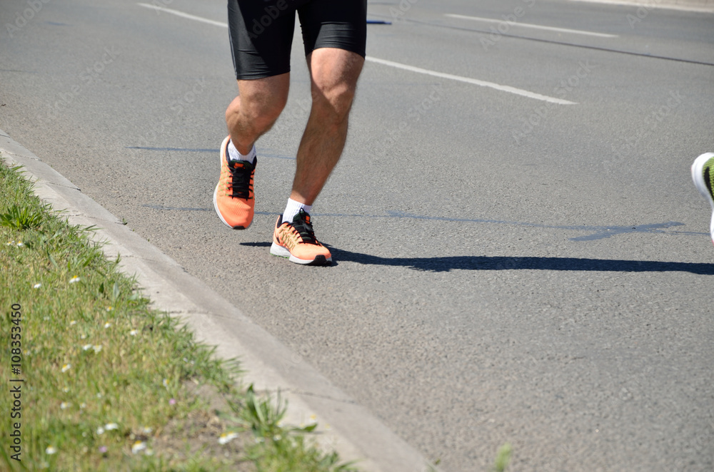 Motion blurred legs of runner in the street race (marathon) in sports gear. Motion blurred legs of runner in the street race (marathon) in sports gear.