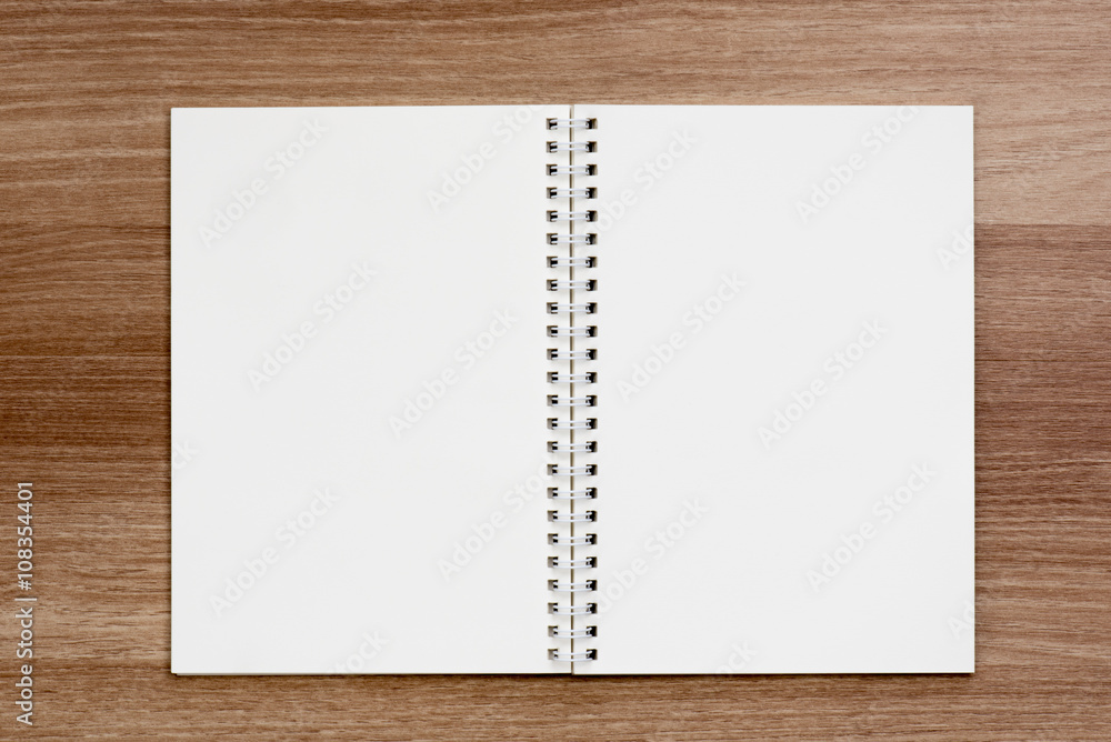 Opened blank ring spiral binding notebook on wooden surface Opened blank ring spiral binding notebook on wooden surface