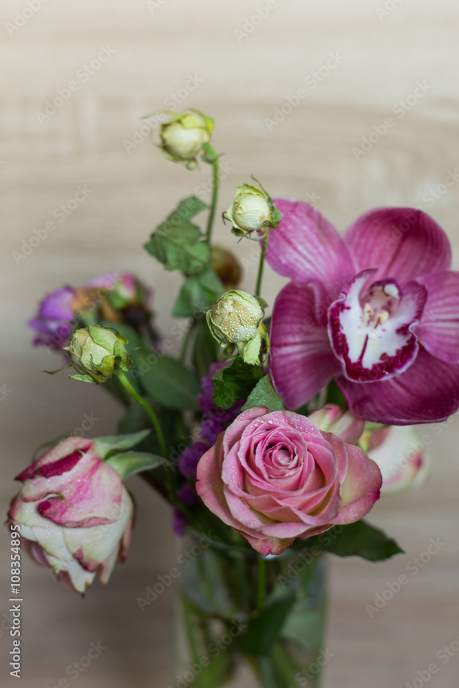 spring bouquet of flowers in a glass vase rose pink orchid on a wooden background spring bouquet of flowers in a glass vase rose pink orchid on a wooden background