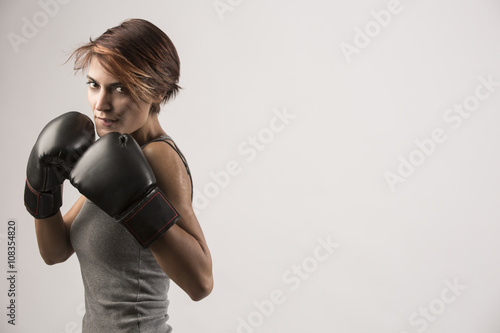 Bellissima donna con guanti da box sta in posizione di guardia sinistra © alex.pin
