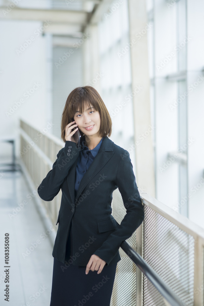 Attractive asian business woman using on smartphone outside Offi Attractive asian business woman using on smartphone outside Offi