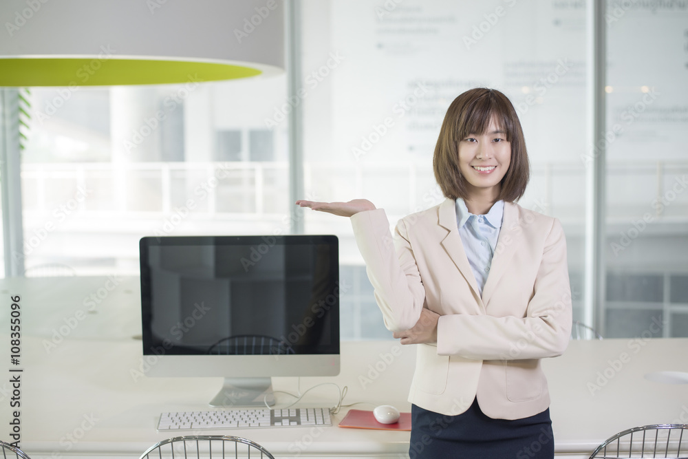 Fototapeta premium Attractive asian business woman showing something on workplace