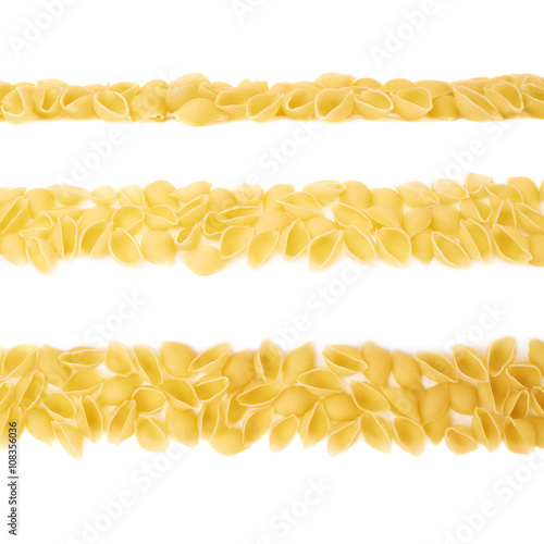 Line made of dry conchiglie pasta over isolated white background