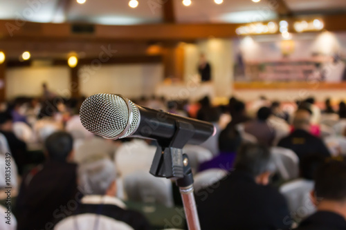 Microphone set up on blurred people in seminar event hall