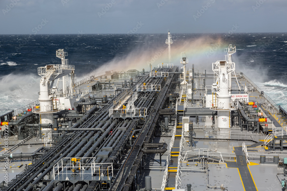 Oil tanker deck during storm with rainbow