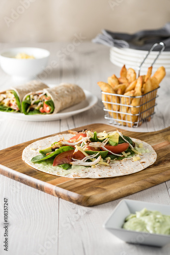 shredded barbecued chicken wraps with carrot, cheese, avocado an