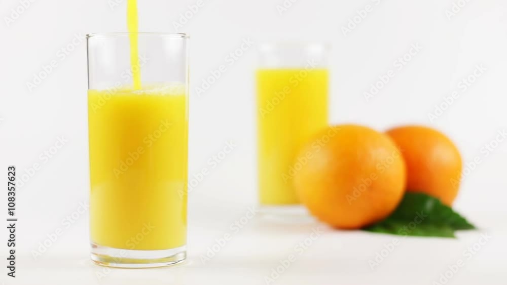 Man pouring orange juice into a glass on a white background Man pouring orange juice into a glass on a white background