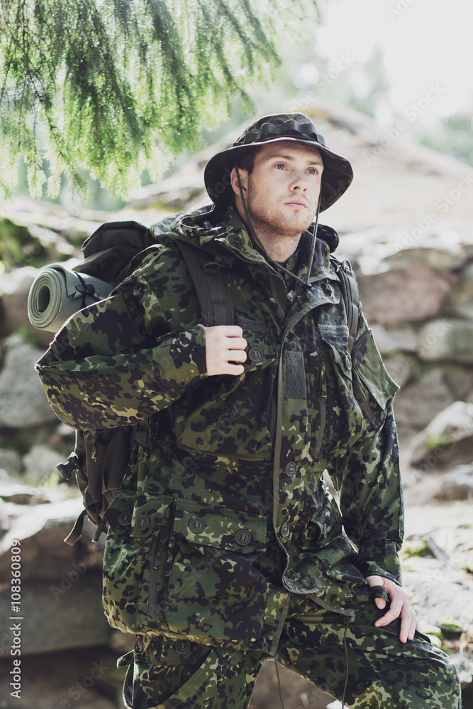 young soldier with backpack in forest young soldier with backpack in forest