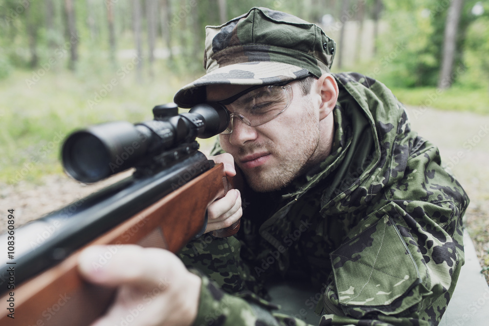 close up of soldier or hunter with gun in forest close up of soldier or hunter with gun in forest