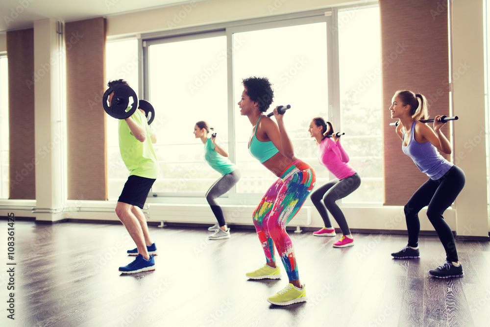 group of people exercising with barbell in gym group of people exercising with barbell in gym