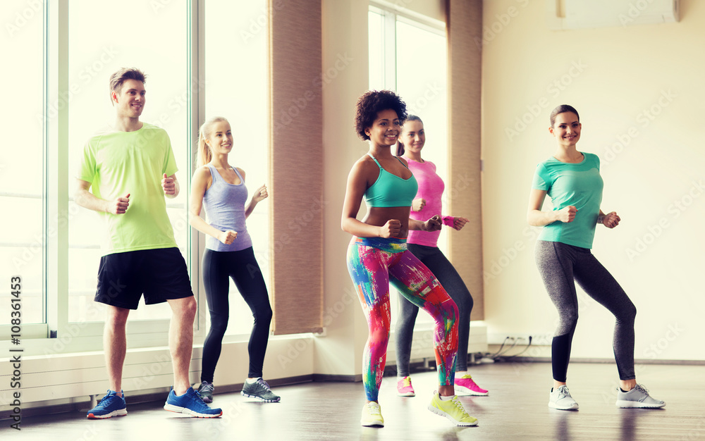 Fototapeta premium group of smiling people dancing in gym or studio
