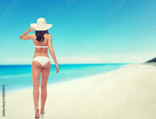 young woman in white bikini swimsuit from back
