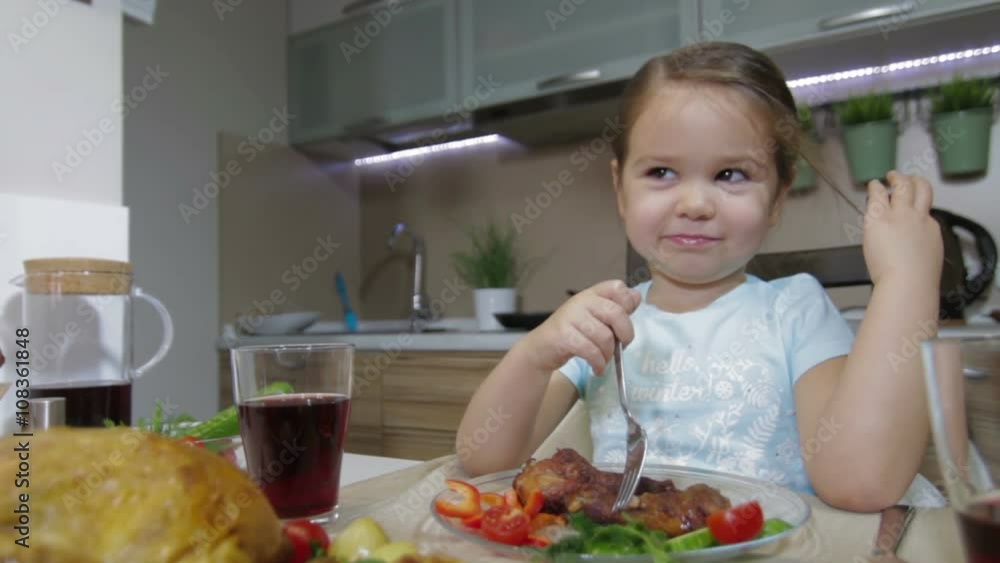 Serious Little girl having family dinner Serious Little girl having family dinner